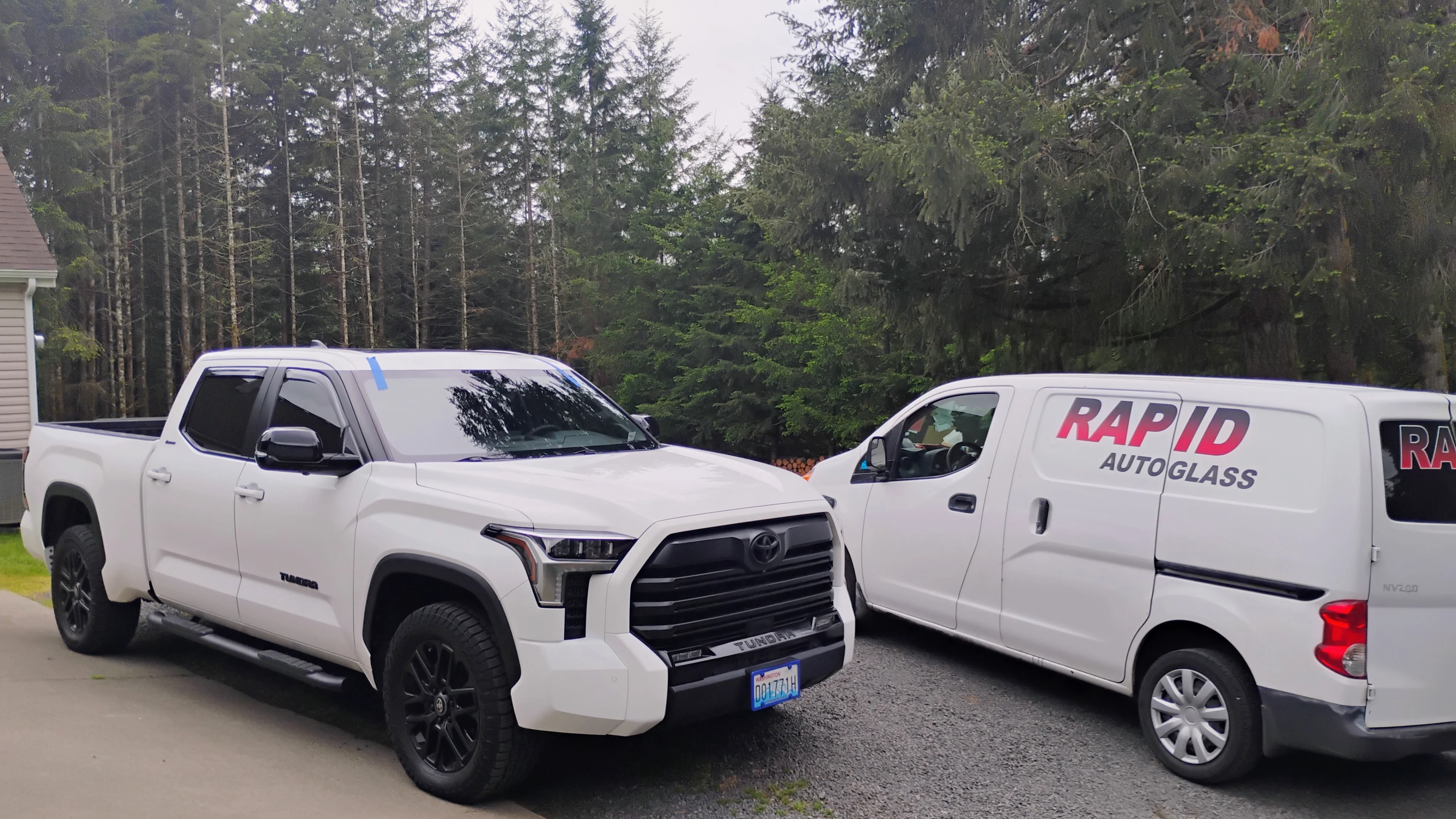 White truck and van parked outside house.