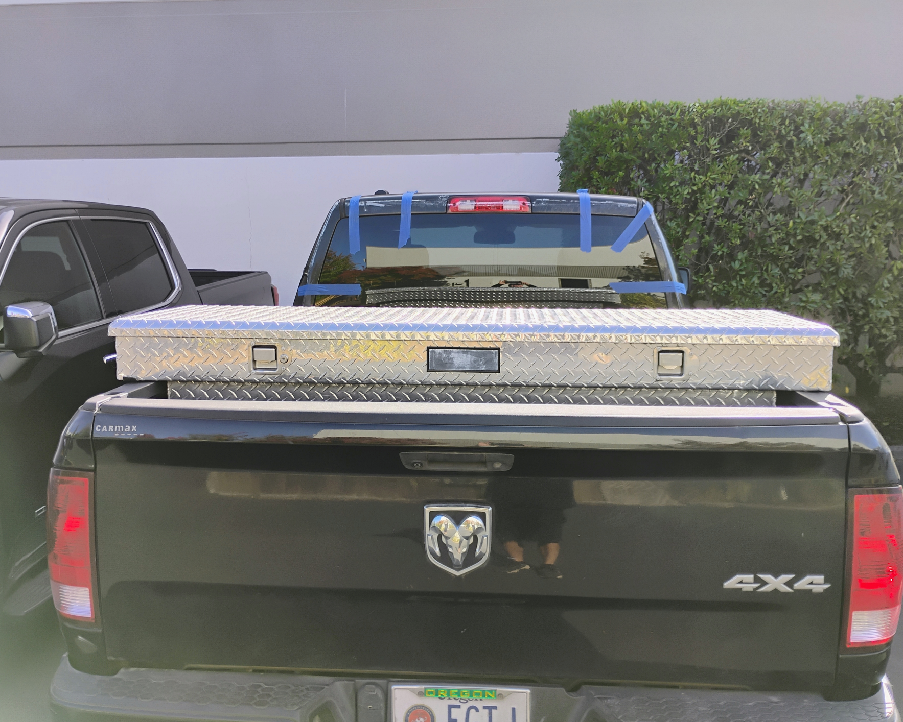 Black pickup truck with a diamond plate toolbox.